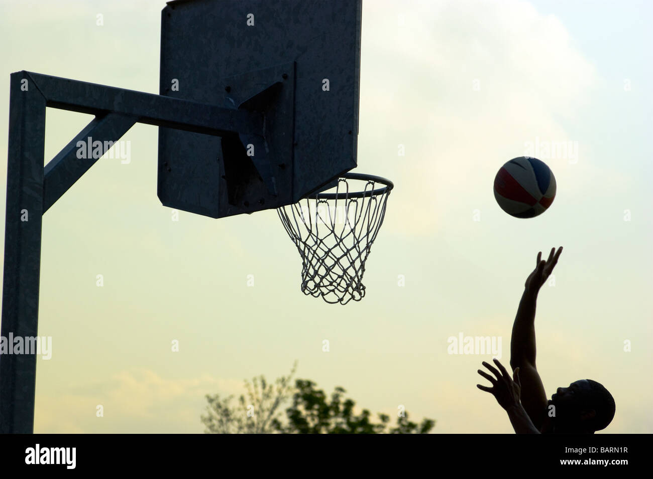 Basketball player shoots on  a Sunday afternoon in Finsbury Park, North London. Stock Photo