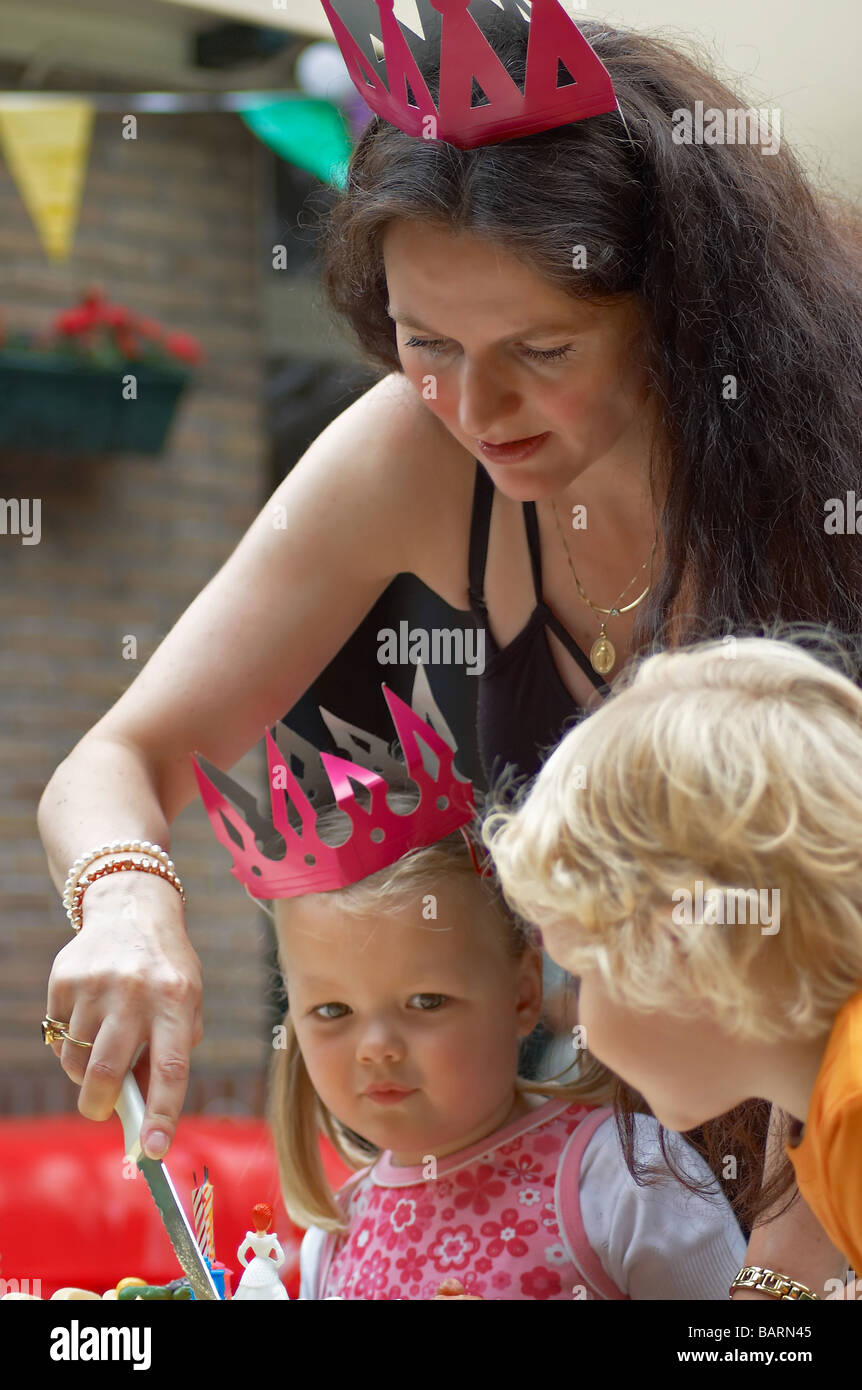 mother is cutting cake for child on birthday Stock Photo