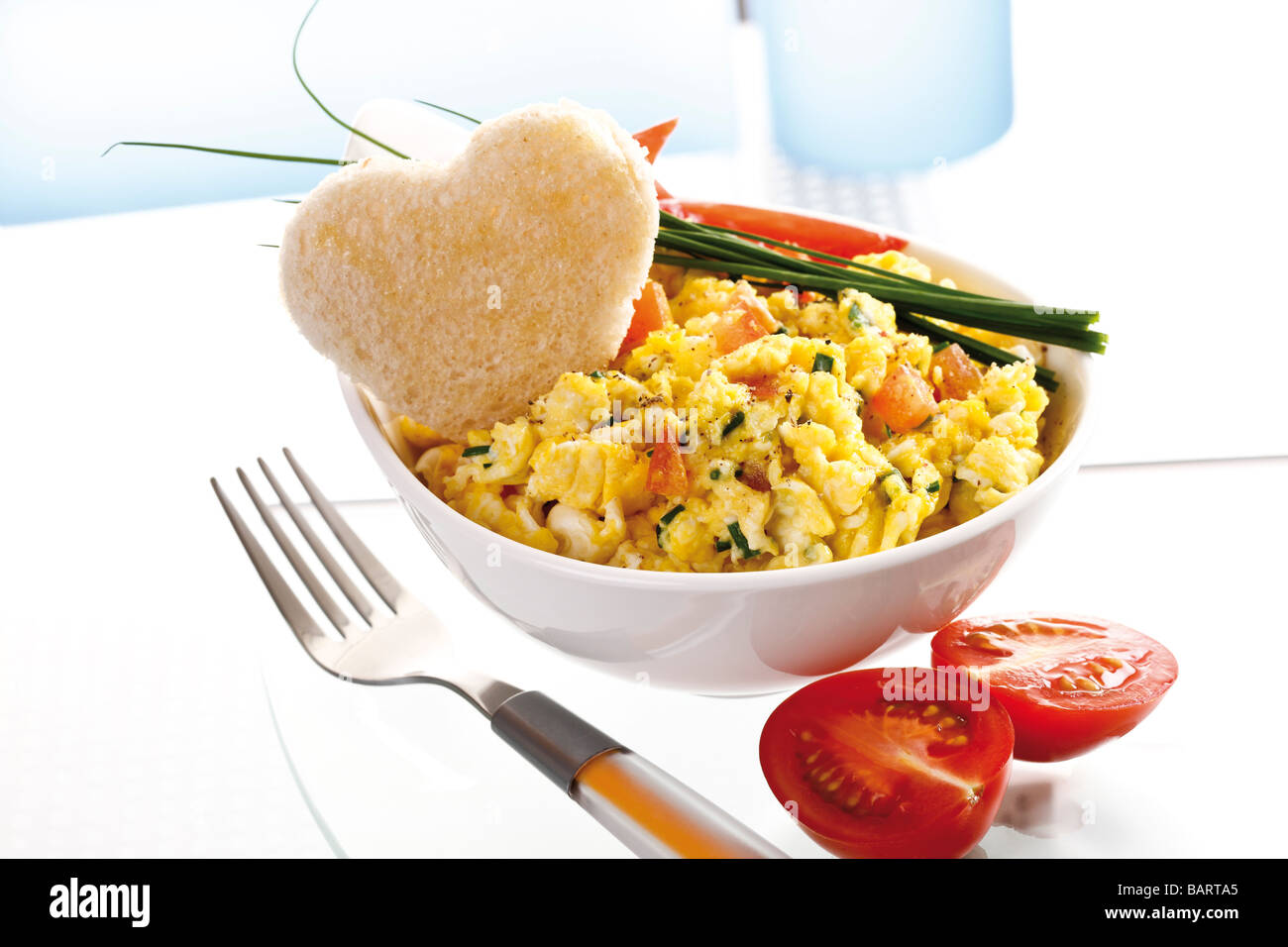 Scrambled eggs with tomatoes in bowl Stock Photo