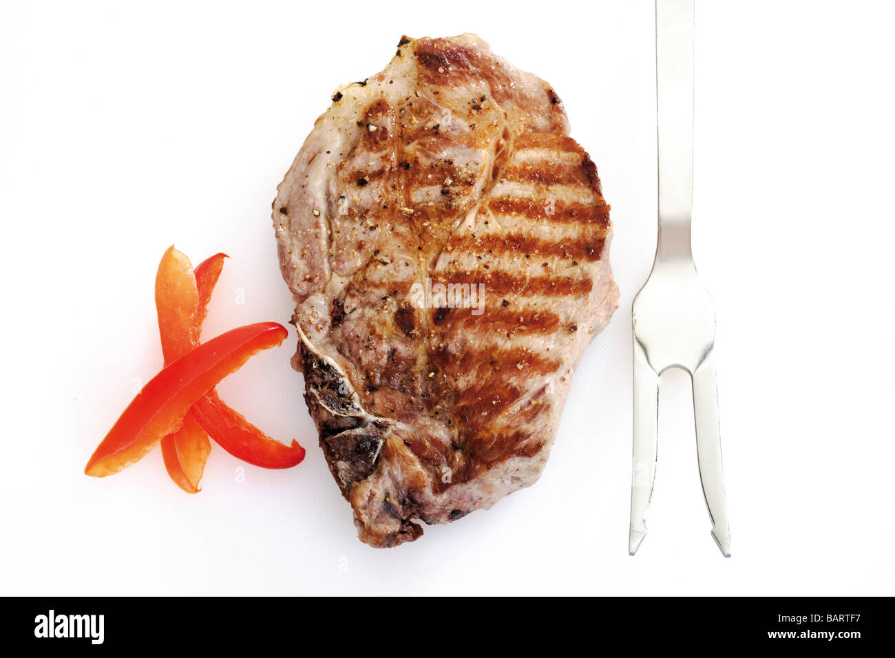 Grilled Pork chop and meat fork, elevated view Stock Photo