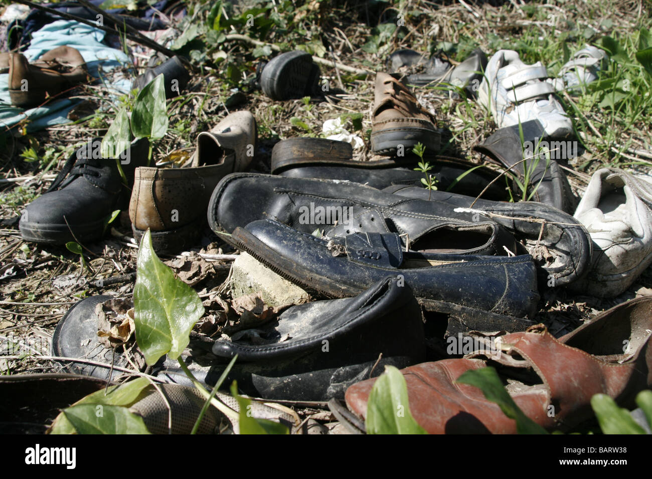 lots of pairs of shoes left in field in countryside Stock Photo