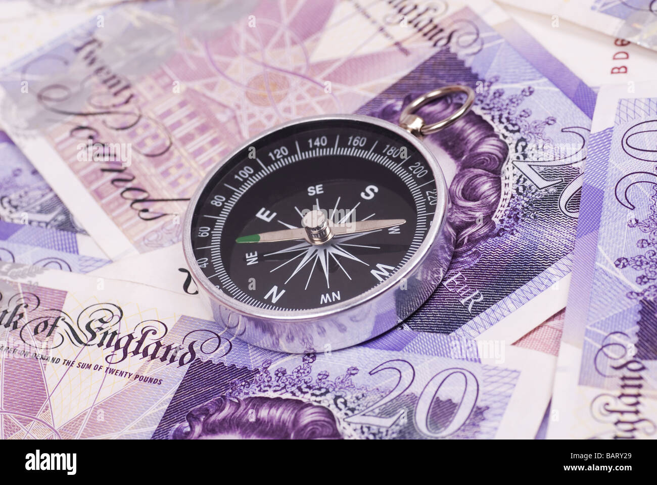 Compass over a pile of British money Stock Photo
