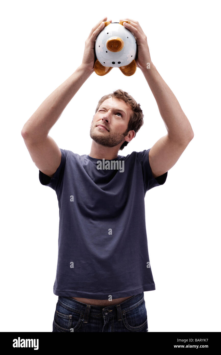 Young man holding piggy bank, portrait Stock Photo - Alamy