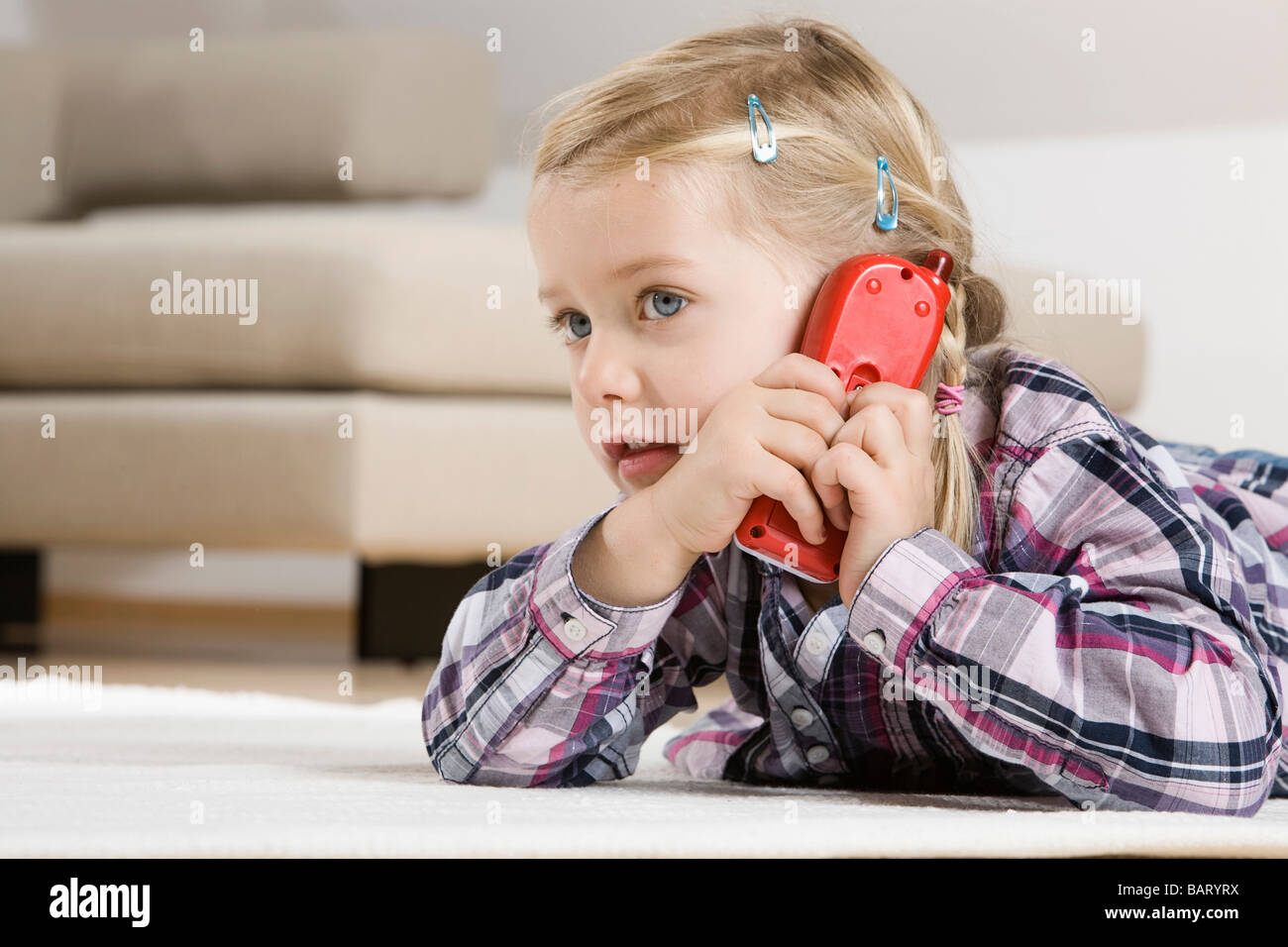Little girl (3-4) using toy phone Stock Photo