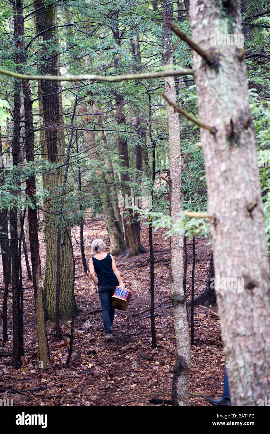 A woman participating in a mushroom hunt in the hills of Rosendale, NY make her way through the woods. Stock Photo