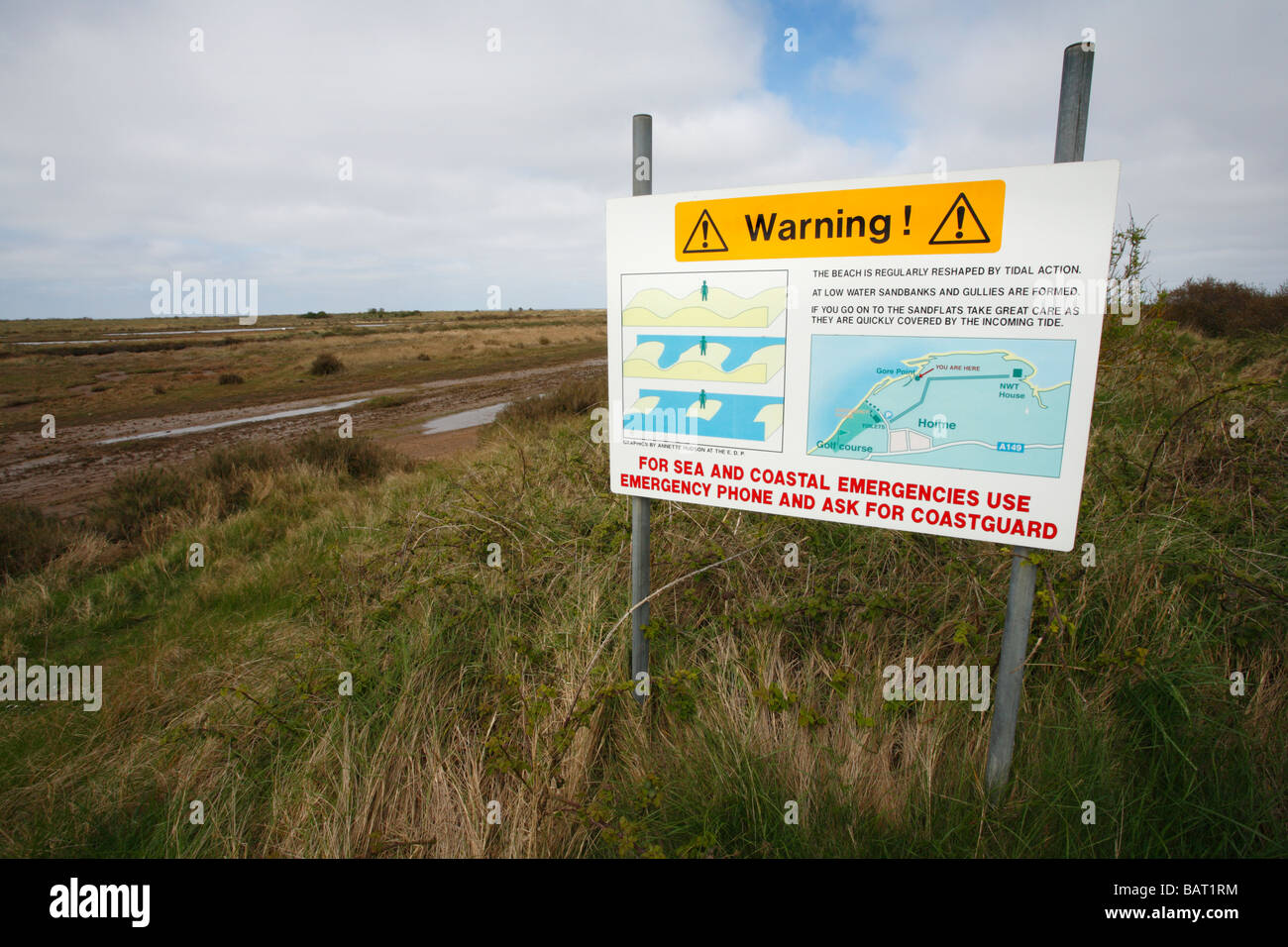 Sign warning of the dangers of incoming tides at the marshes of Holme Dunes nature reserve. Stock Photo