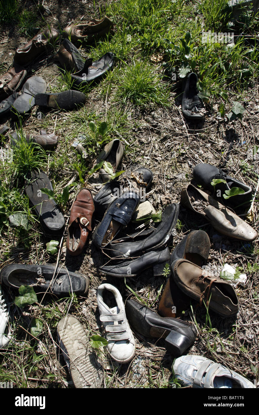 lots of pairs of shoes left in field in countryside Stock Photo