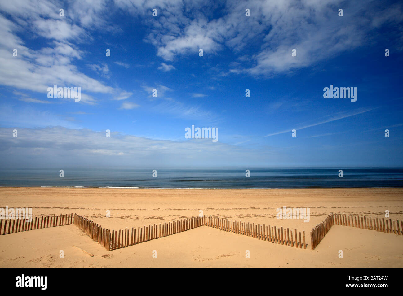 Wooden posts on the sandy beach at Holme on the North Norfolk coast. Stock Photo
