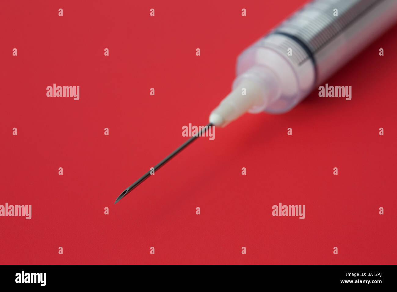 Studio still life Syringe with needle in close up on a red background Stock Photo