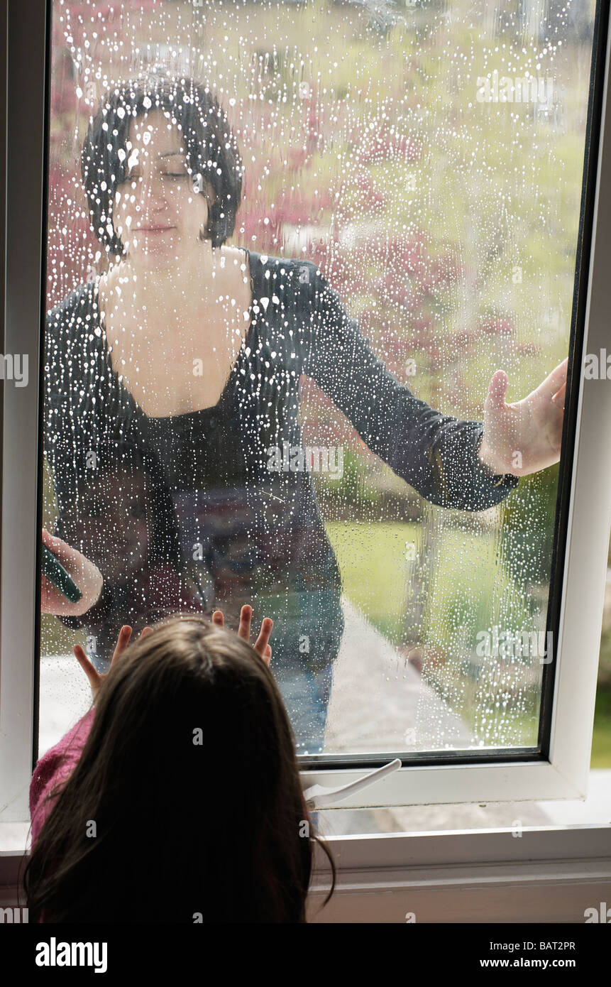 Spring clean mother and child cleaning bedroom window Stock Photo