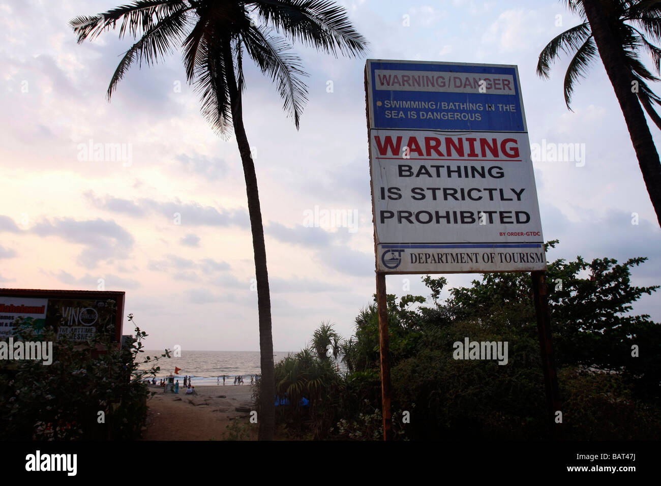 A board warns tourists against swimming in the sea at Vagator beach in northern Goa in India. Stock Photo