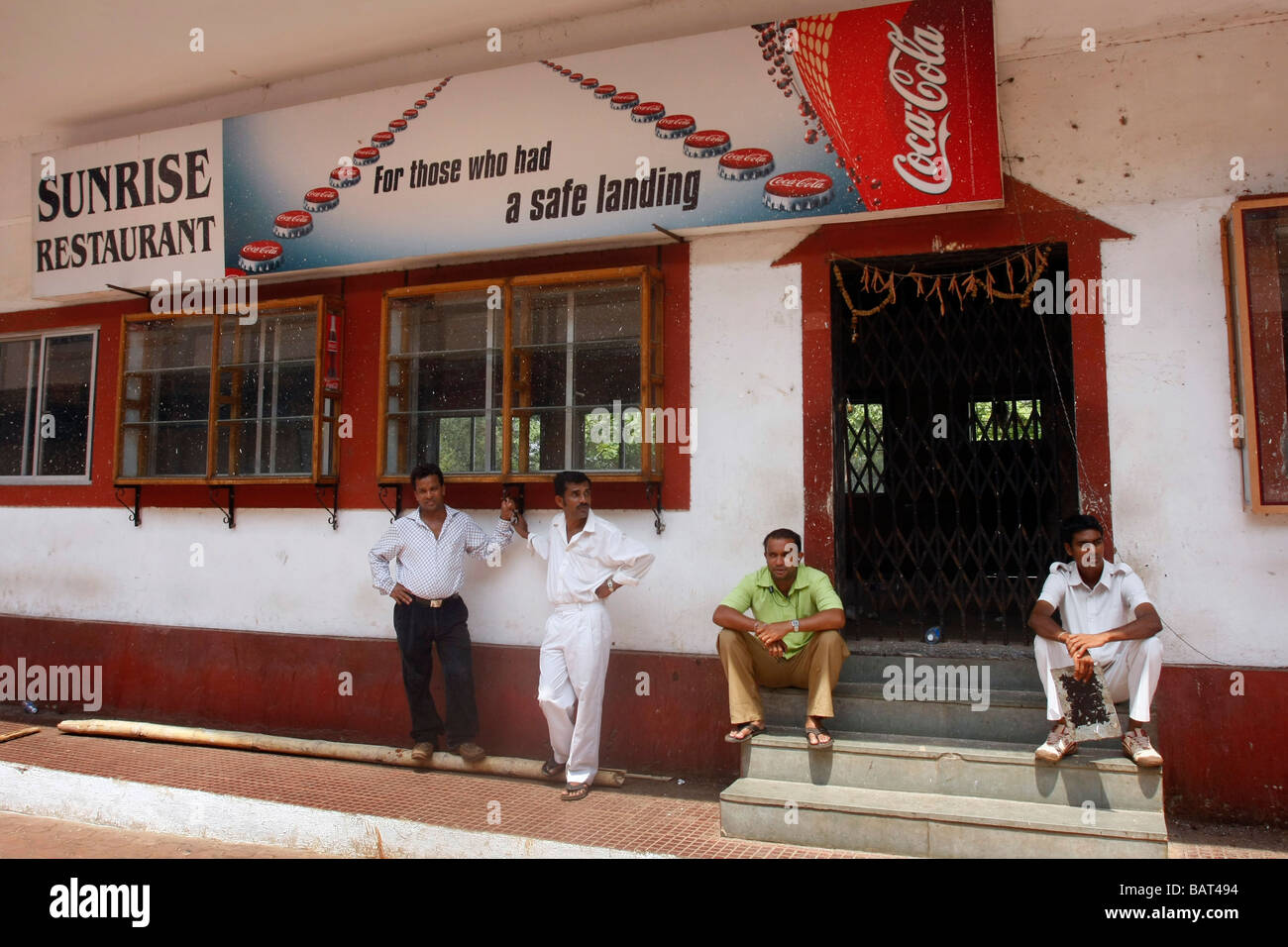 People sit outside a restaurant located at the Dabolim Airport in Goa in India. Stock Photo
