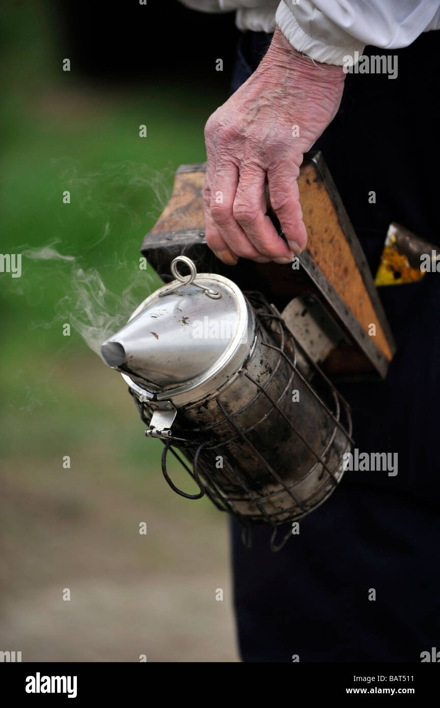 smoker canister being held by older beekeeper Stock Photo