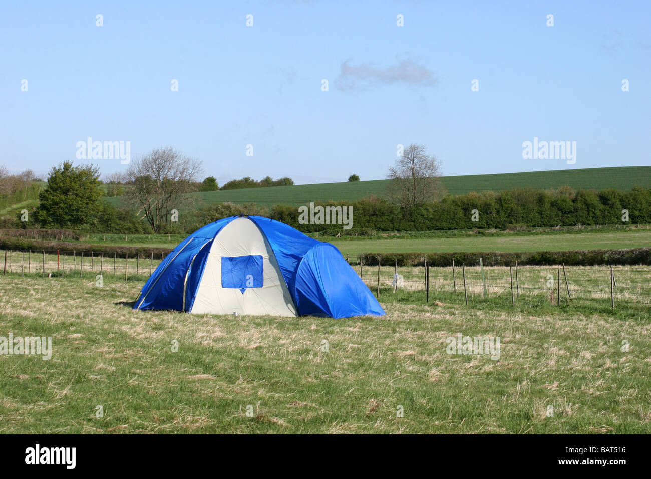Camping tent in a field with blue sky Stock Photo