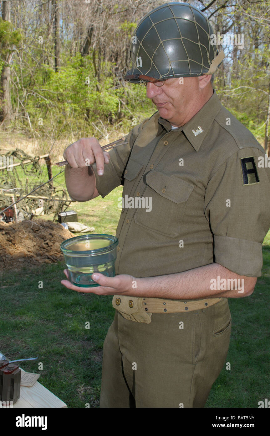 Man dressed as a American WWII soldier displays a mine that injured or killed hundreds during WWII at a WWII reenactment in Md Stock Photo