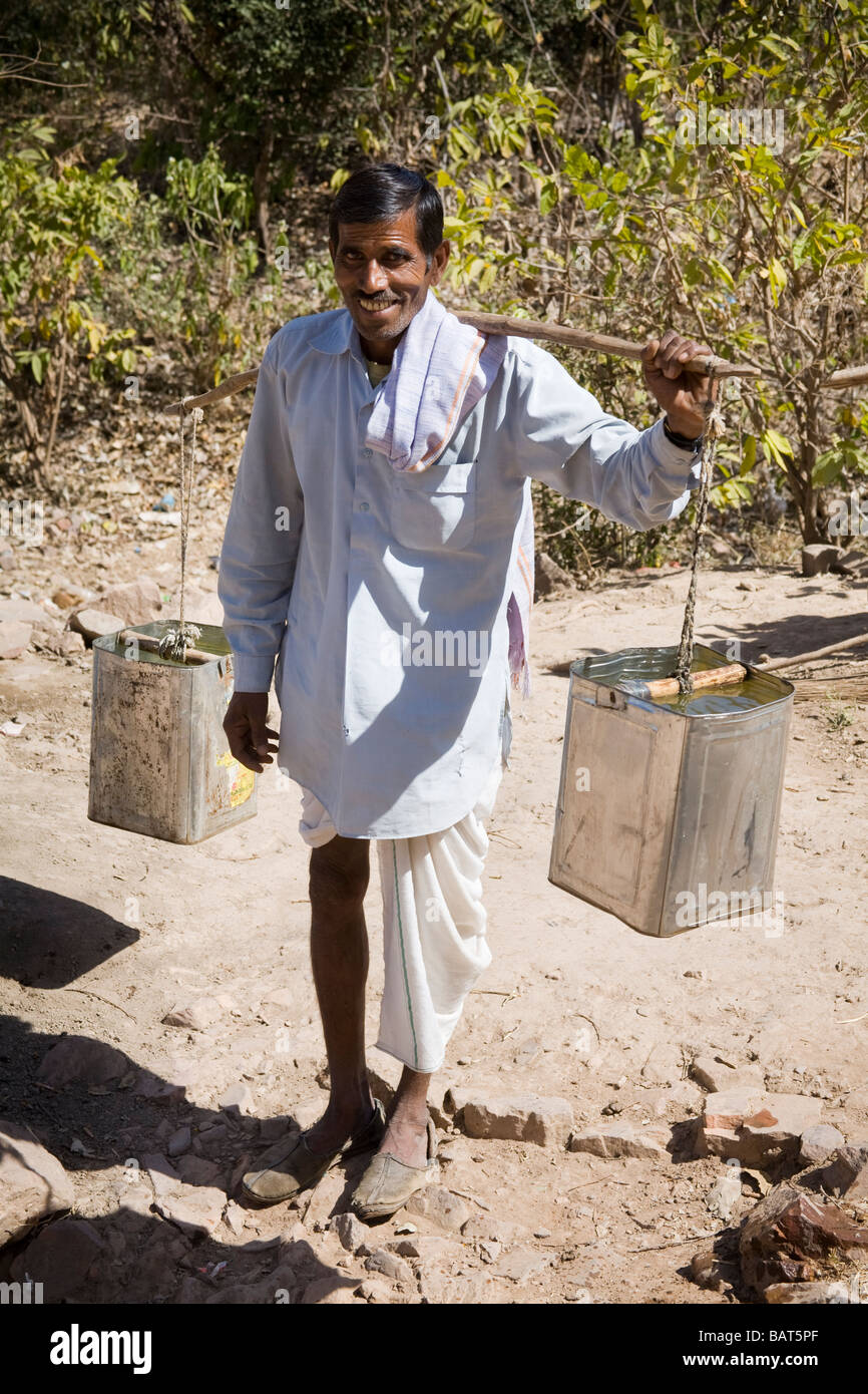 Man carrying containers full of water, in Ranthambhore Fort, Ranthambhore National Park, Rajasthan, India Stock Photo
