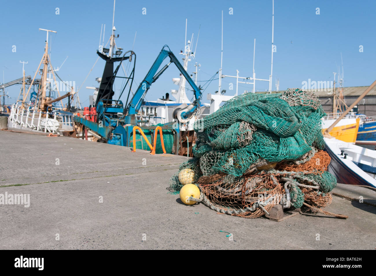 Trawler fishing nets piled up at Portavogie harbour Stock Photo