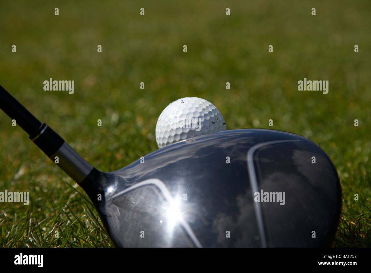 used golf ball sitting on the tee with driver club behind at the start
