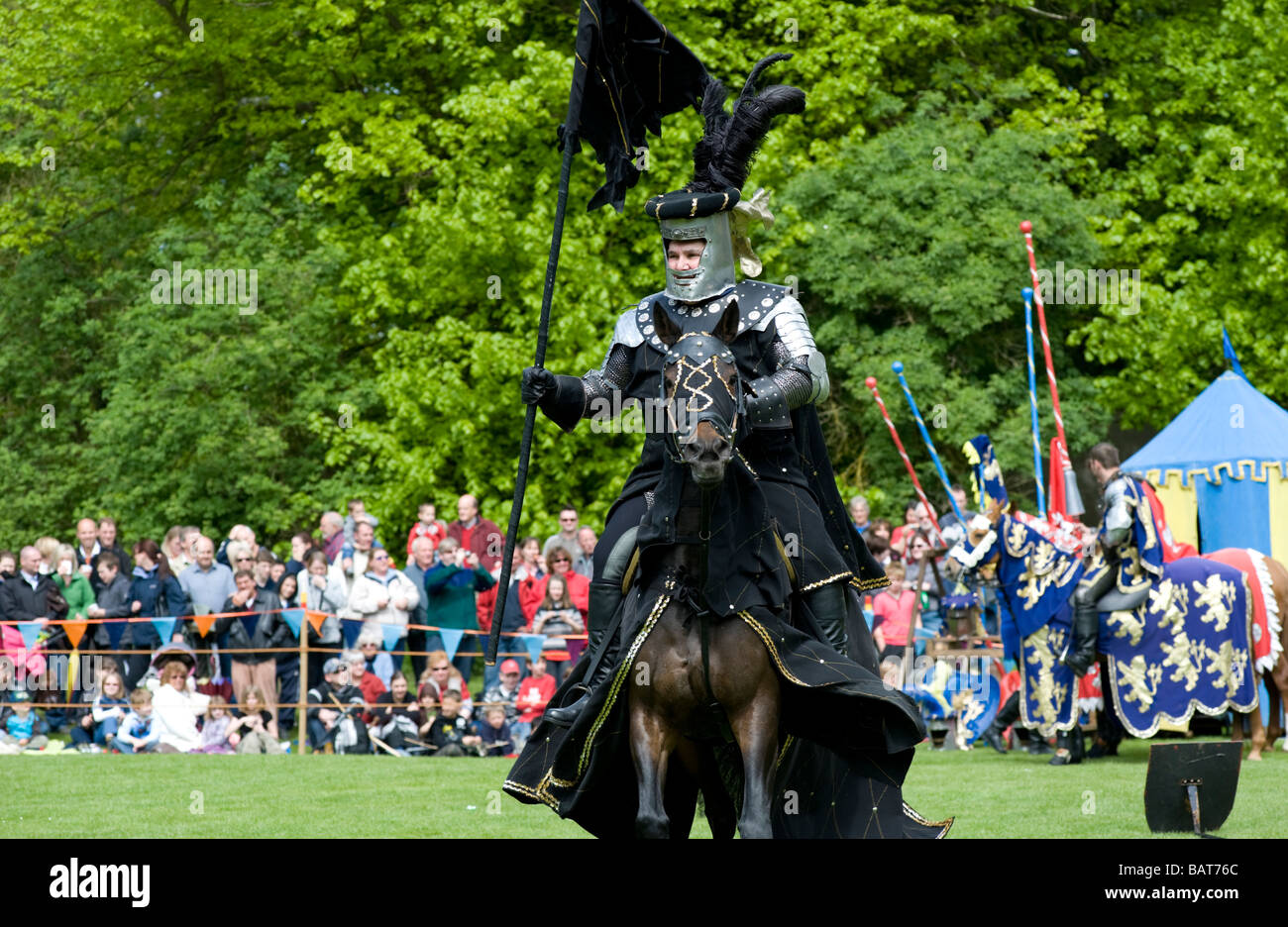 Black knight parades before battle at a jousting tournament at Hedingham Castle, Essex, UK Stock Photo