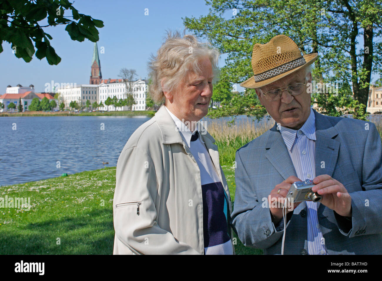 senior couple checking their digital photos at the lakefront of Schwerin in Mecklenburg Western-Pomerania Stock Photo