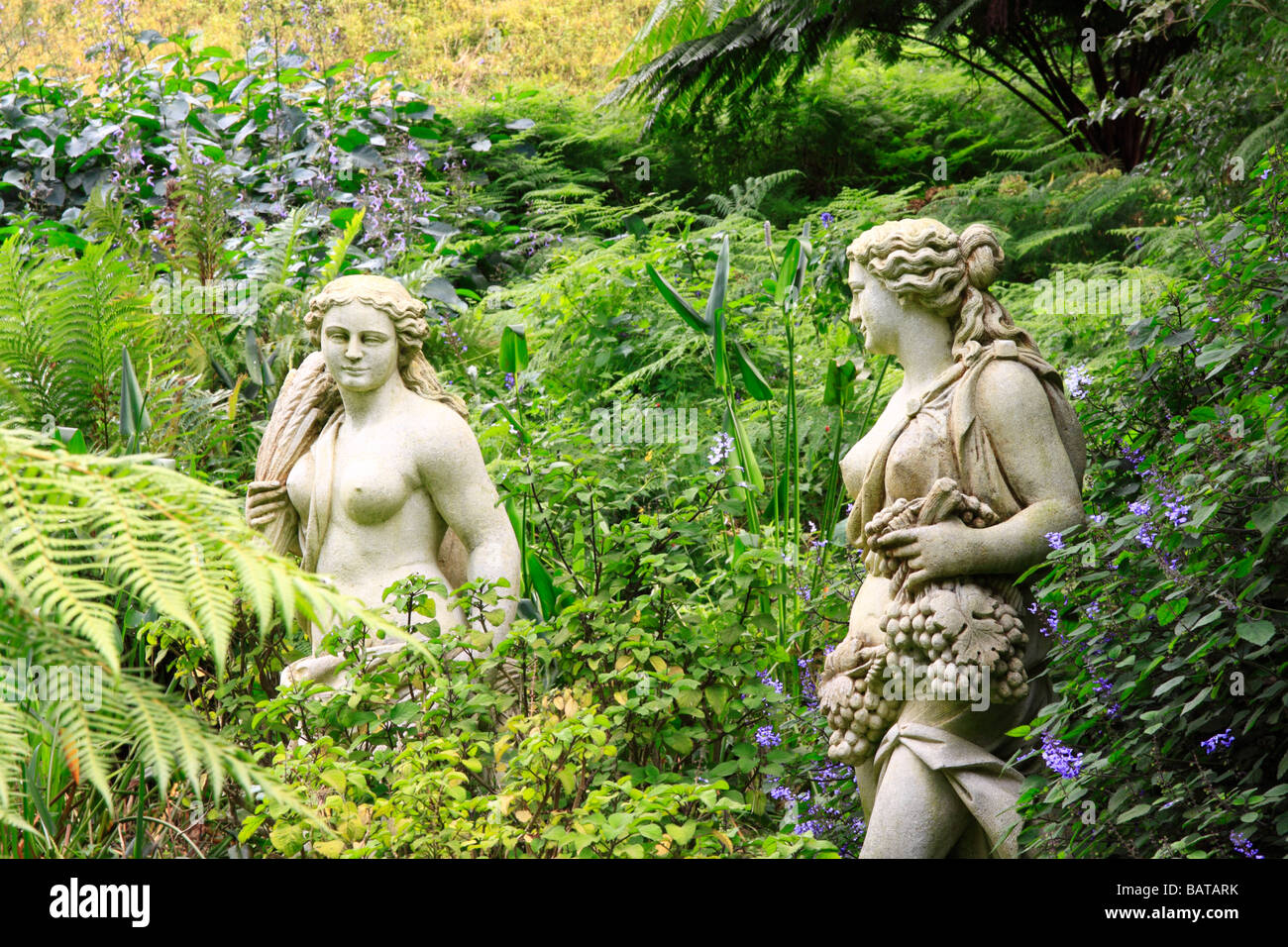 Semi nude statue figures in flower garden Stock Photo