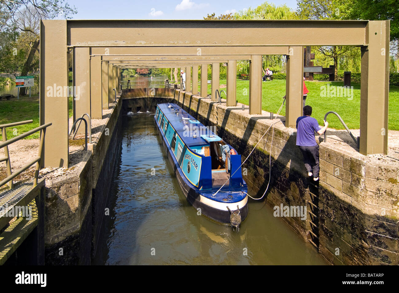 Horizontal wide angle of a traditional narrowboat inside the chamber of a filling lock on the River Avon on a sunny day Stock Photo