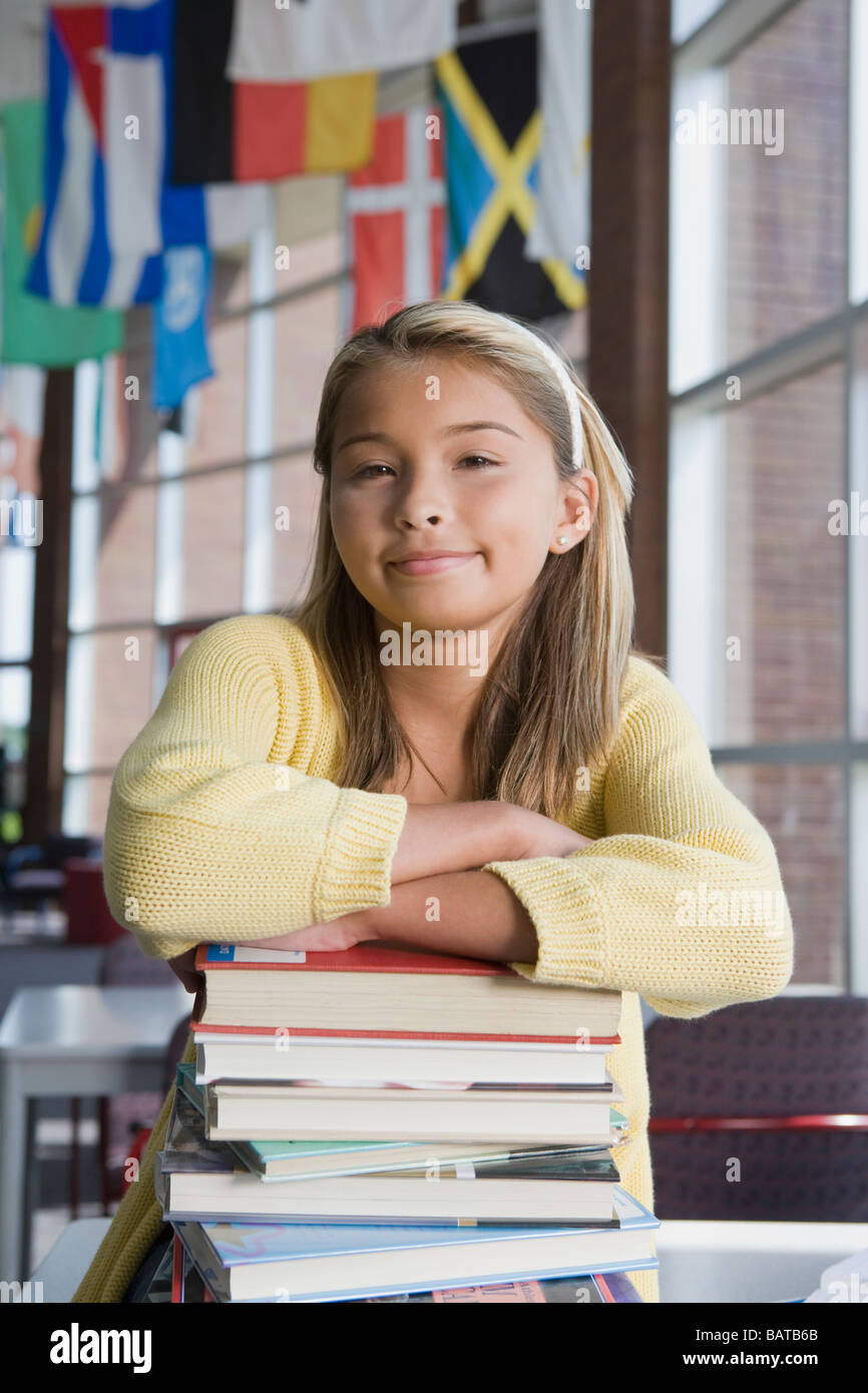 Asian girl leaning on stack of books Stock Photo - Alamy