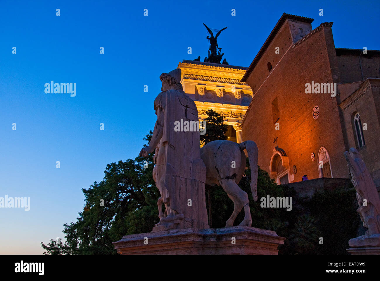 Night view of statue of Castor and the church of Ara Coeli and Vittoriano in Rome - Italy Stock Photo