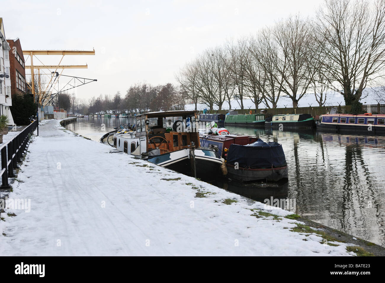 The Lea valley canal with snow covered path and boats,Hackney,London Stock Photo