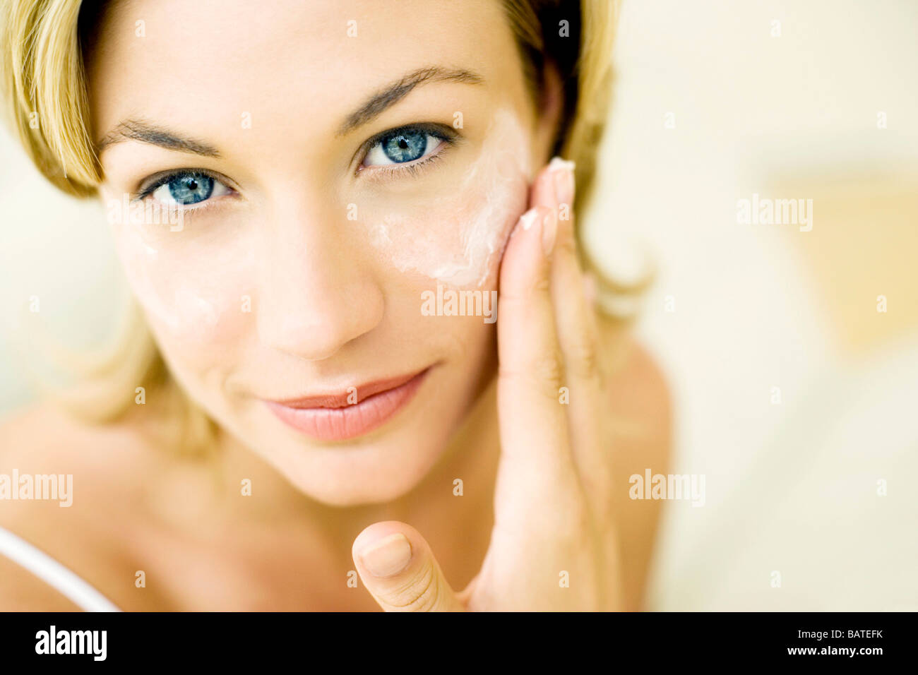 Anti-wrinkle cream. Woman with dots of cream on the wrinkles around her eye. Stock Photo