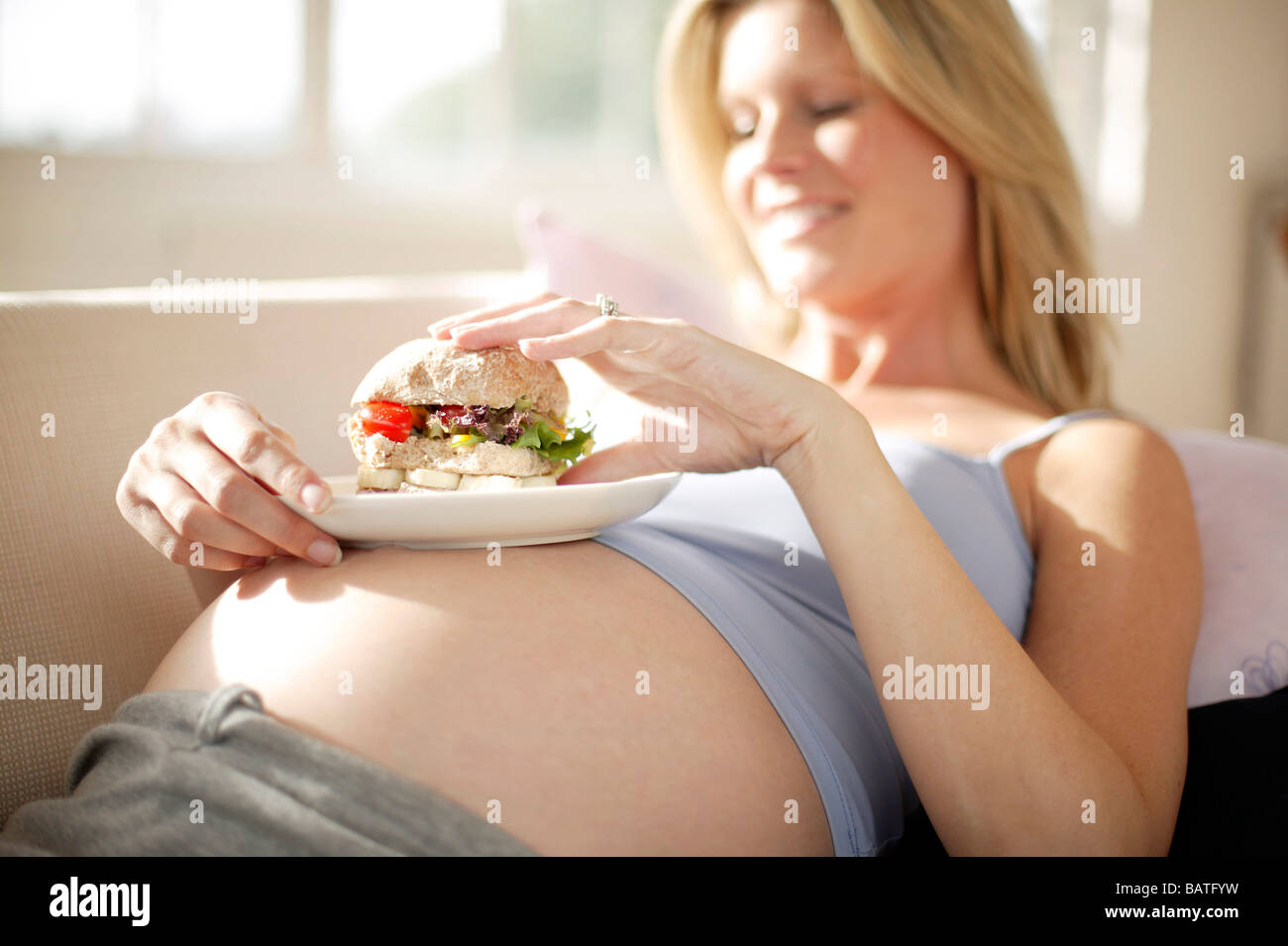 Pregnant woman eating a sandwich Stock Photo Alamy