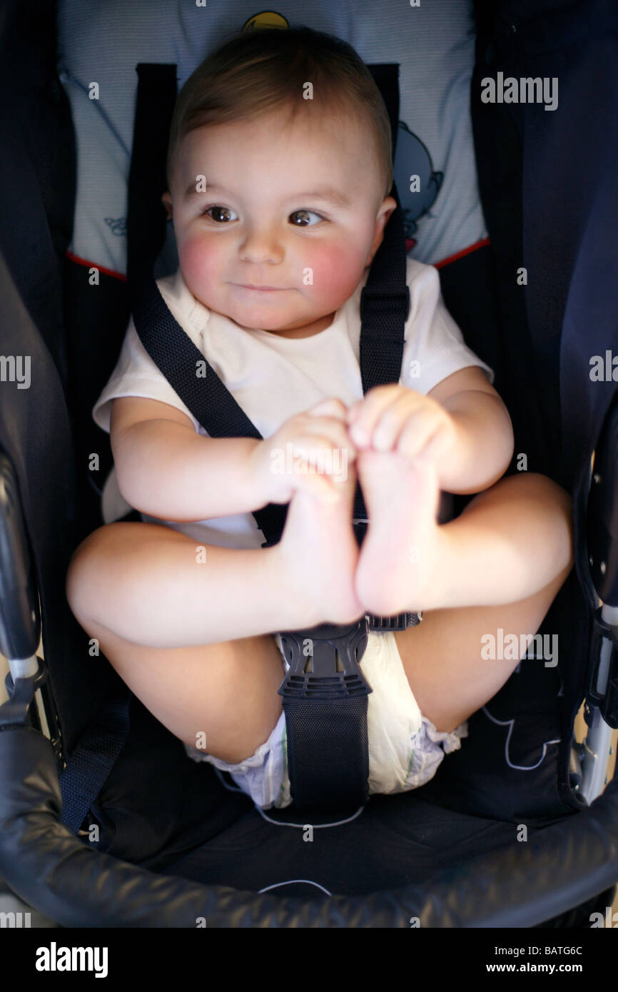 Child safety. Nine month old boy strapped into a car safety seat. Stock Photo