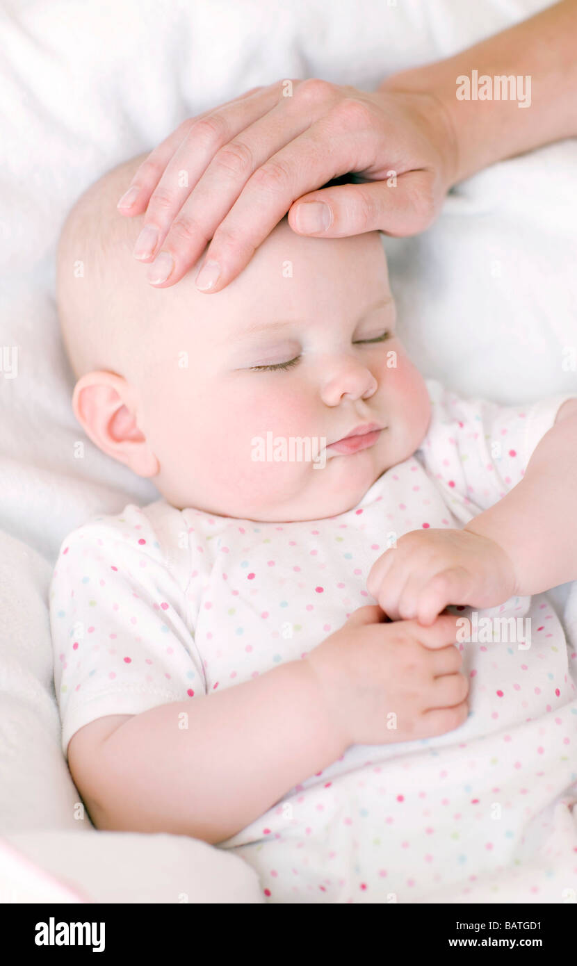 Checking a baby's temperature. Feeling the forehead of a 7 month old