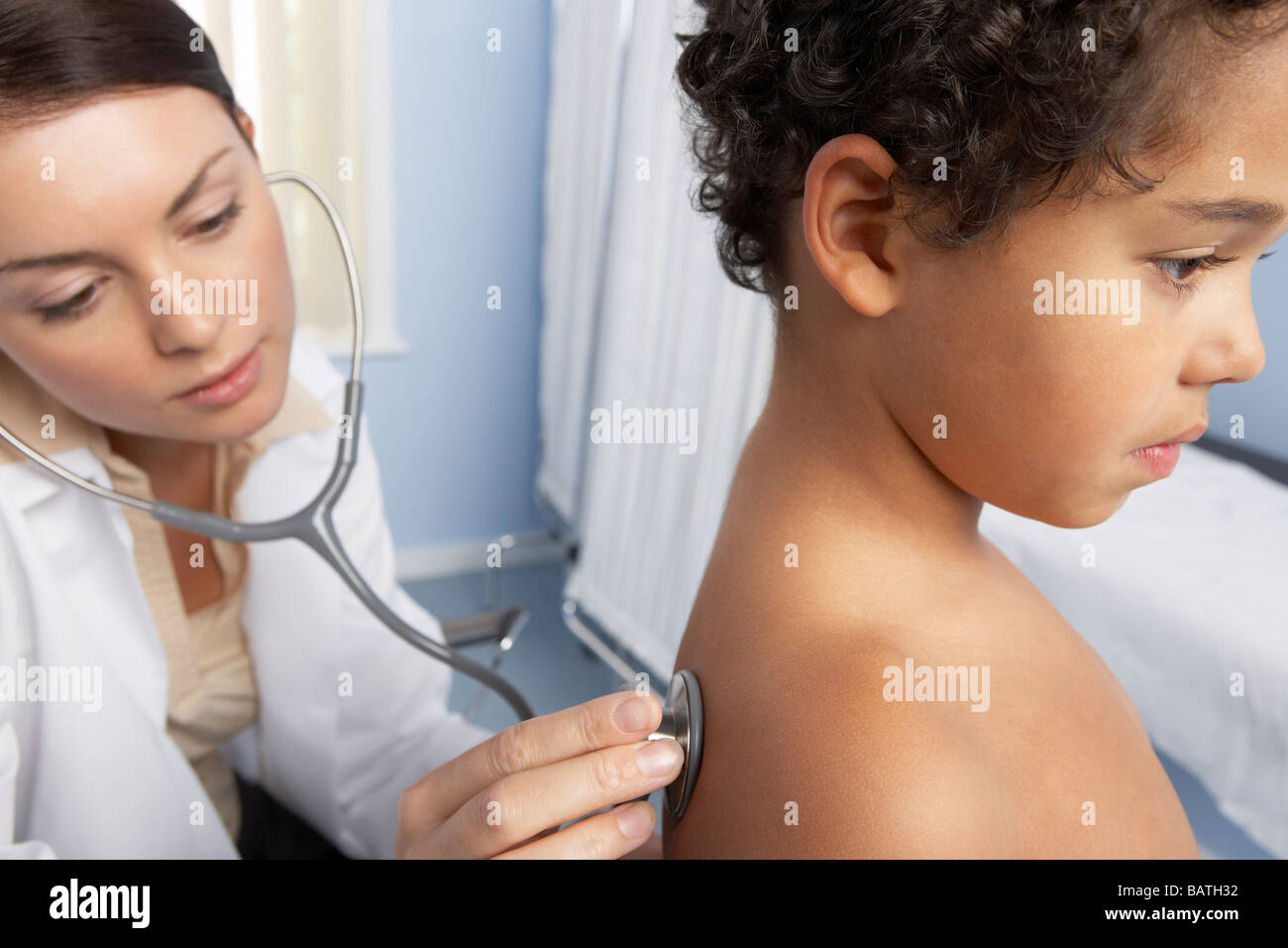 Paediatric doctor using a stethoscope to listen to the back (heart and