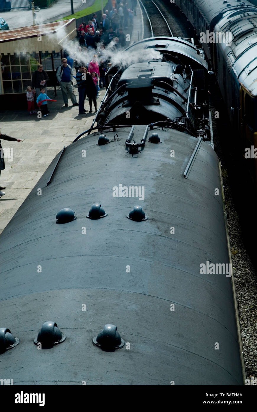 Steam engine train arriving at the train station Stock Photo