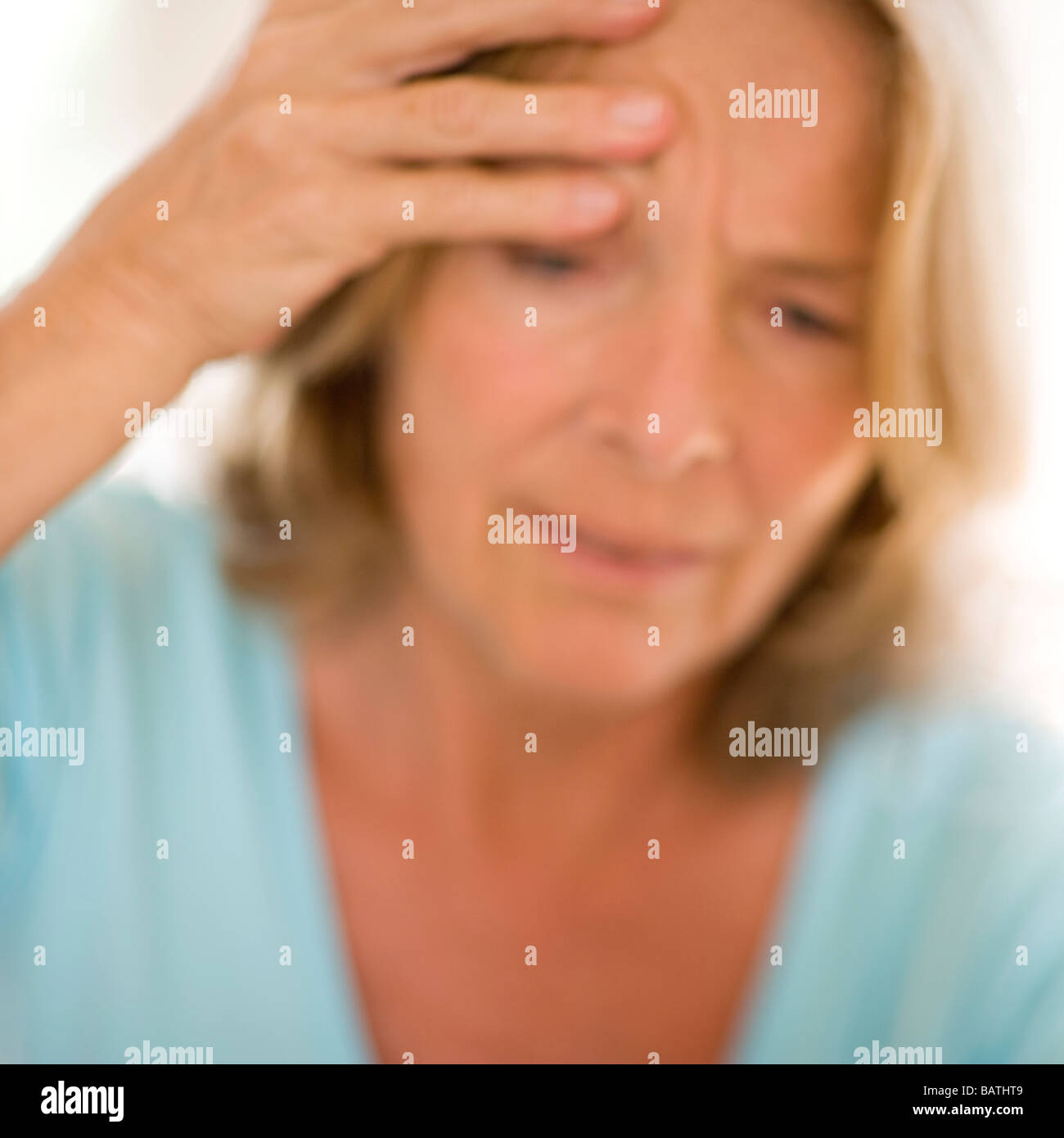 Headache. Woman touching her head due to the pain of a headache Stock