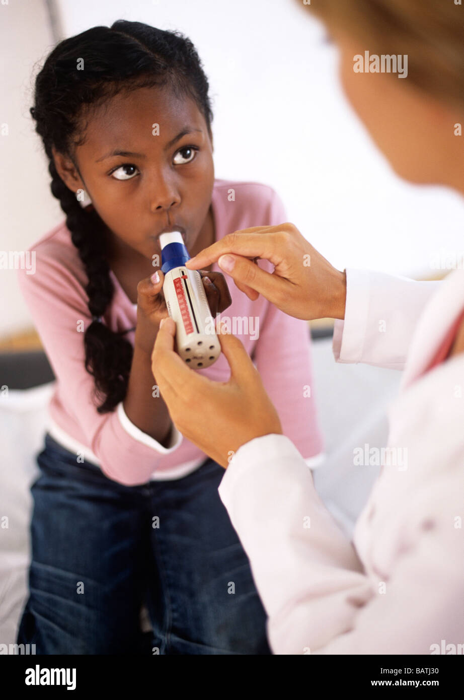 Lung fucntion test. Nine year old girl breathing into a peak flow meter