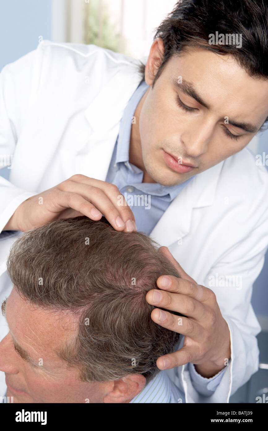 Hair transplant consultation. Trichologist examining the scalp of a man