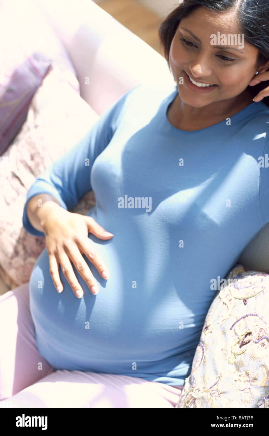 Pregnant Woman Smiling Whileresting Her Hand On Her Swollen Abdomen She Iseight Months 32