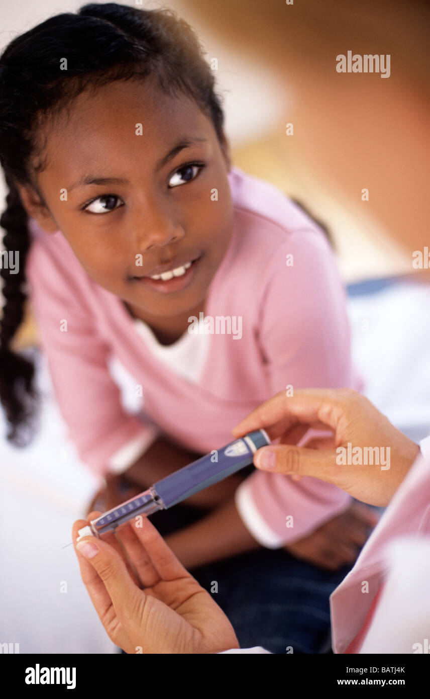 Fiveyearold girl with the conditon diabetes mellitus injecting herself with insulin using