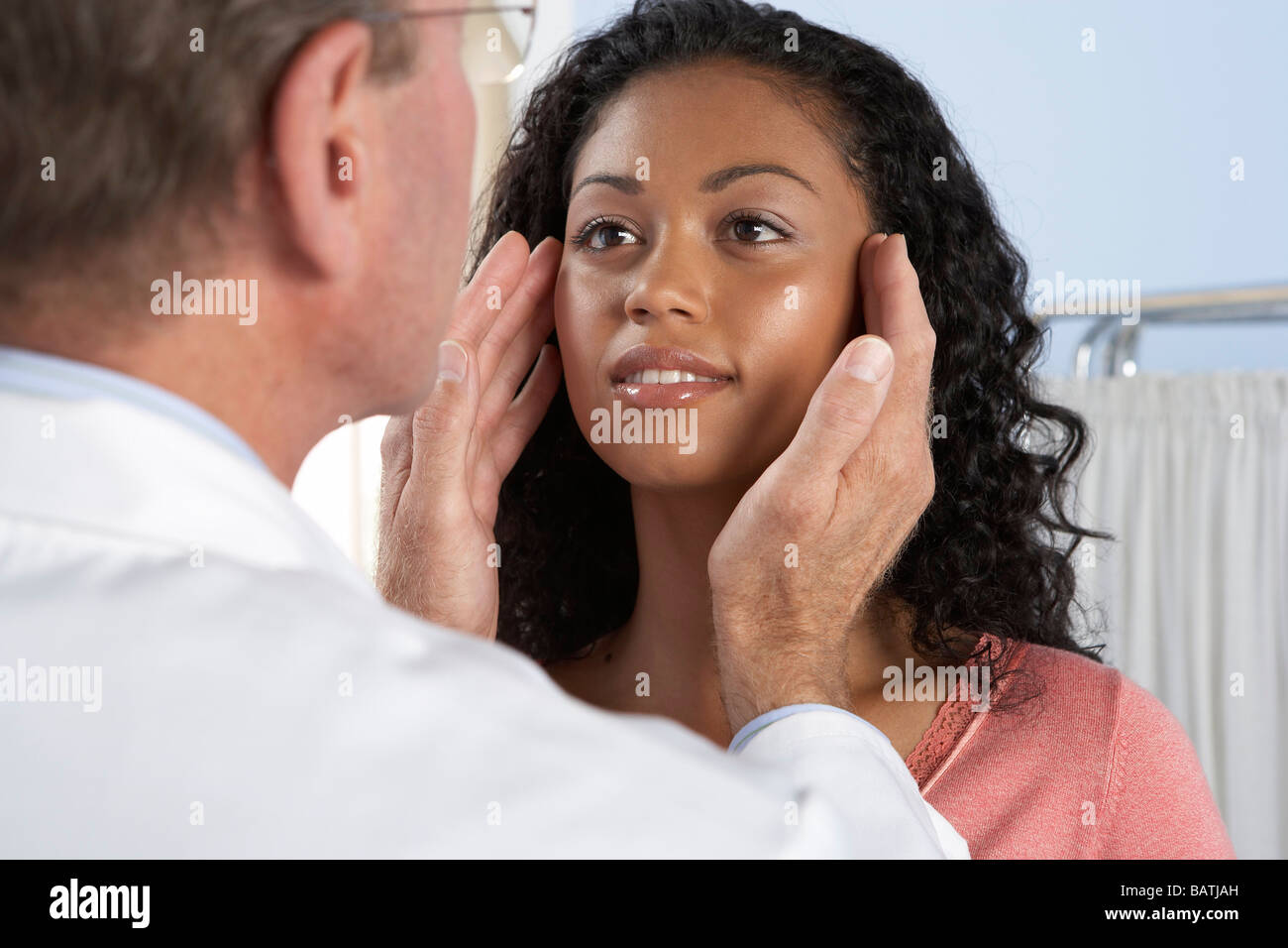 Cosmetic surgery. Consultant examining the face of a young woman