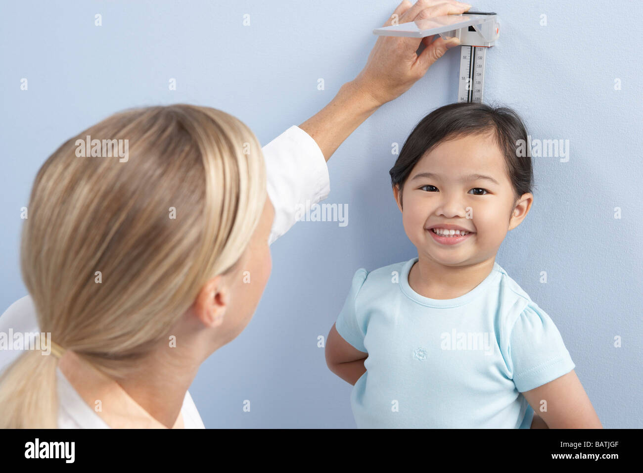 Child height measurement. Doctor measuring the height of a young girl during a check-up. Stock Photo