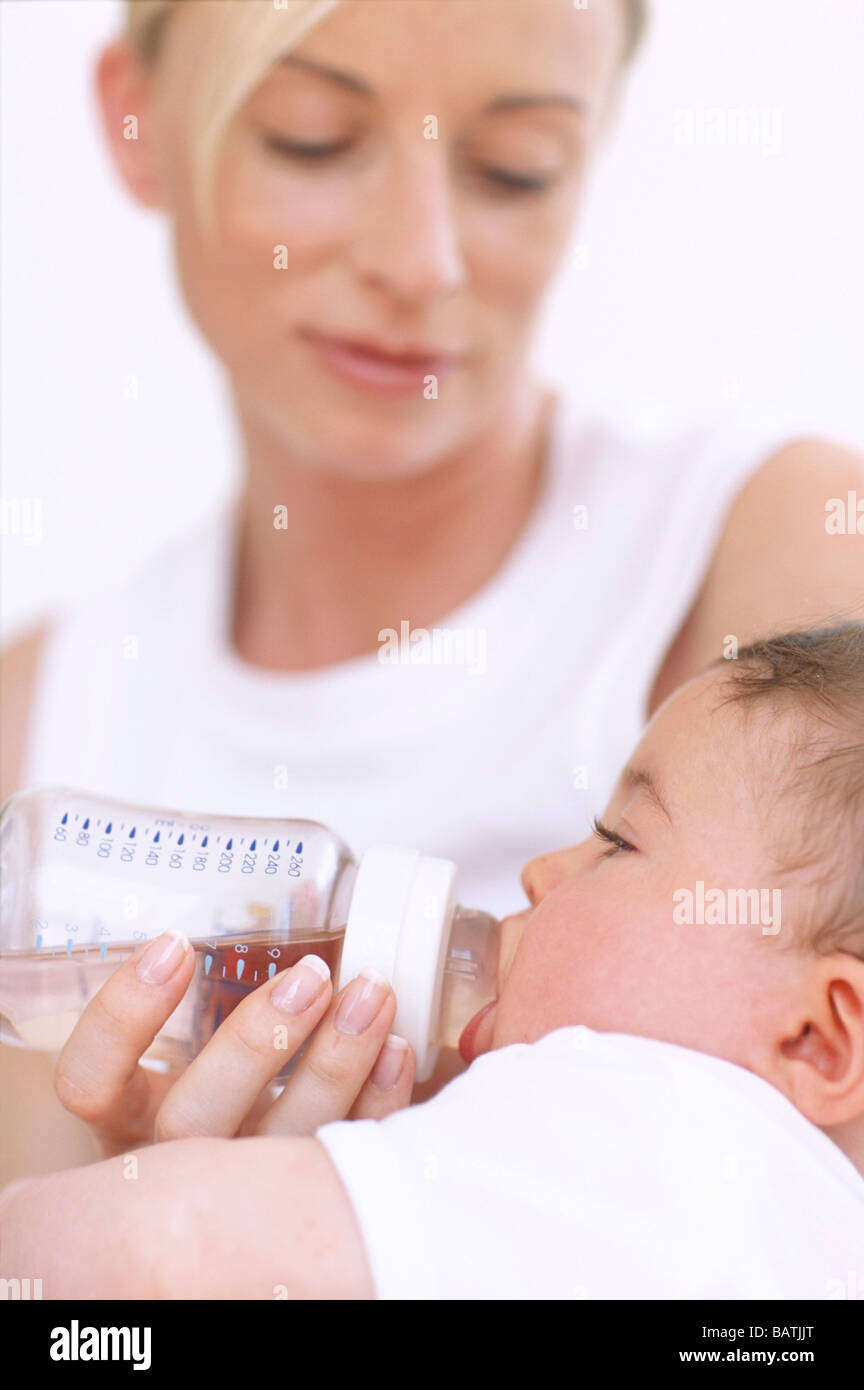 Mother bottlefeeding baby. Mother using a bottle to feed milk to her 2