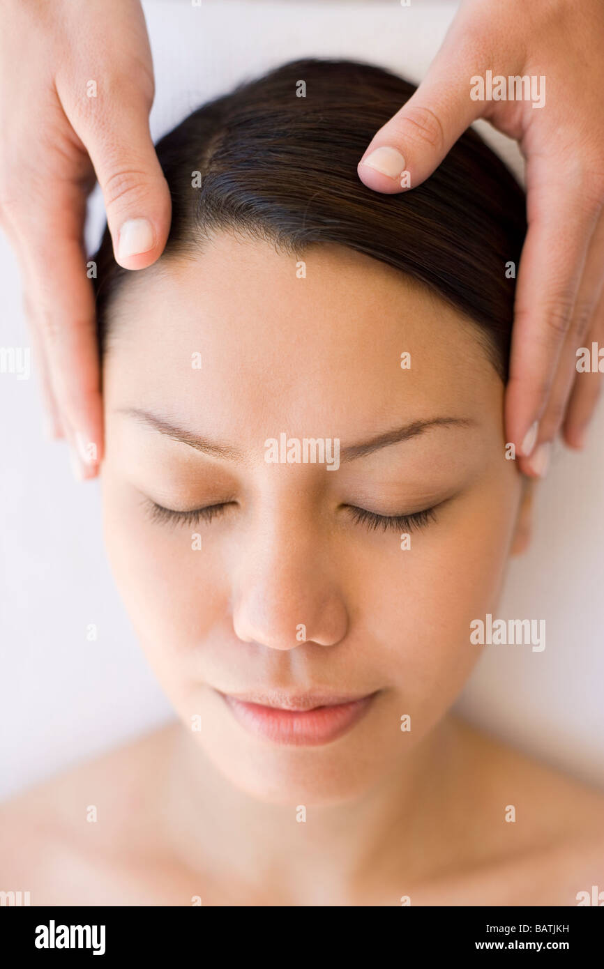Massage. Woman receiving a temple massage Stock Photo - Alamy