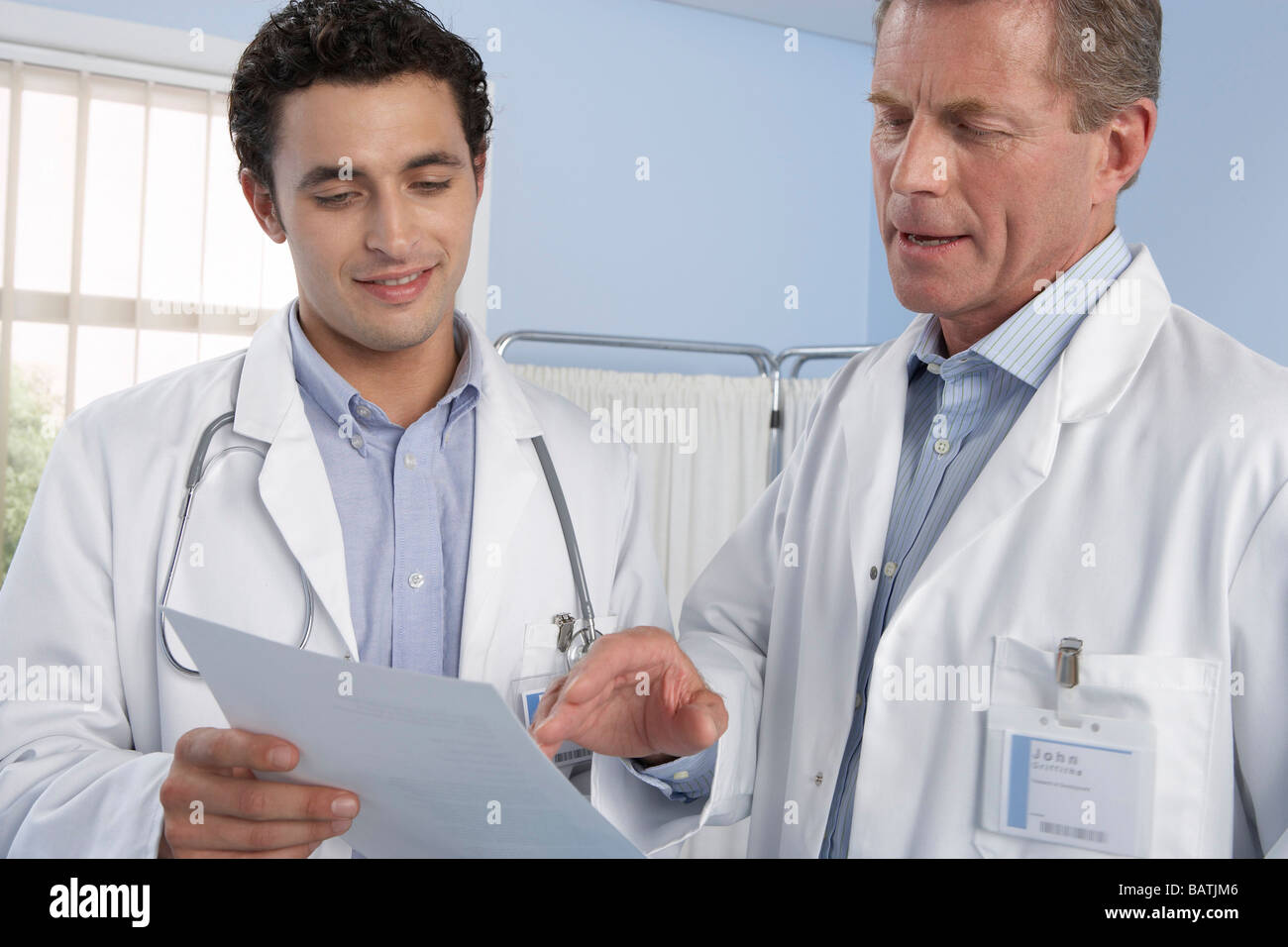 Doctors talking. Two doctors discussing a patient's medical records. Stock Photo