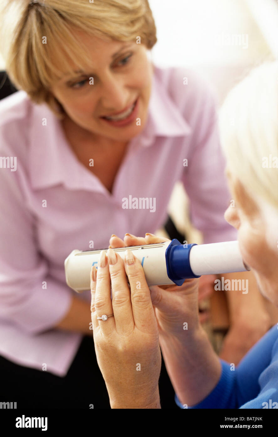 Lung function test. 63yearold woman breathing into a peak flow meter