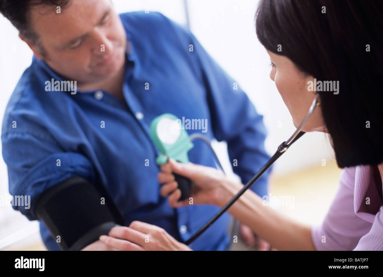 Blood pressure measurement. Sphygmomanometer and stethoscope being used