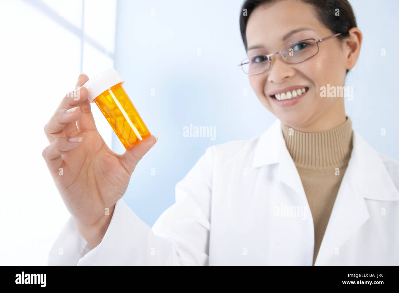 Female general practitioner with a bottle of pills. Stock Photo