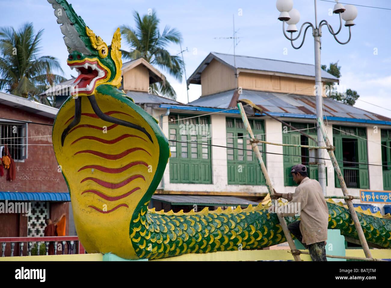 Man painting a Naga (dragon serpent) statue. Botataung  Paya. Yangon. Myanmar Stock Photo