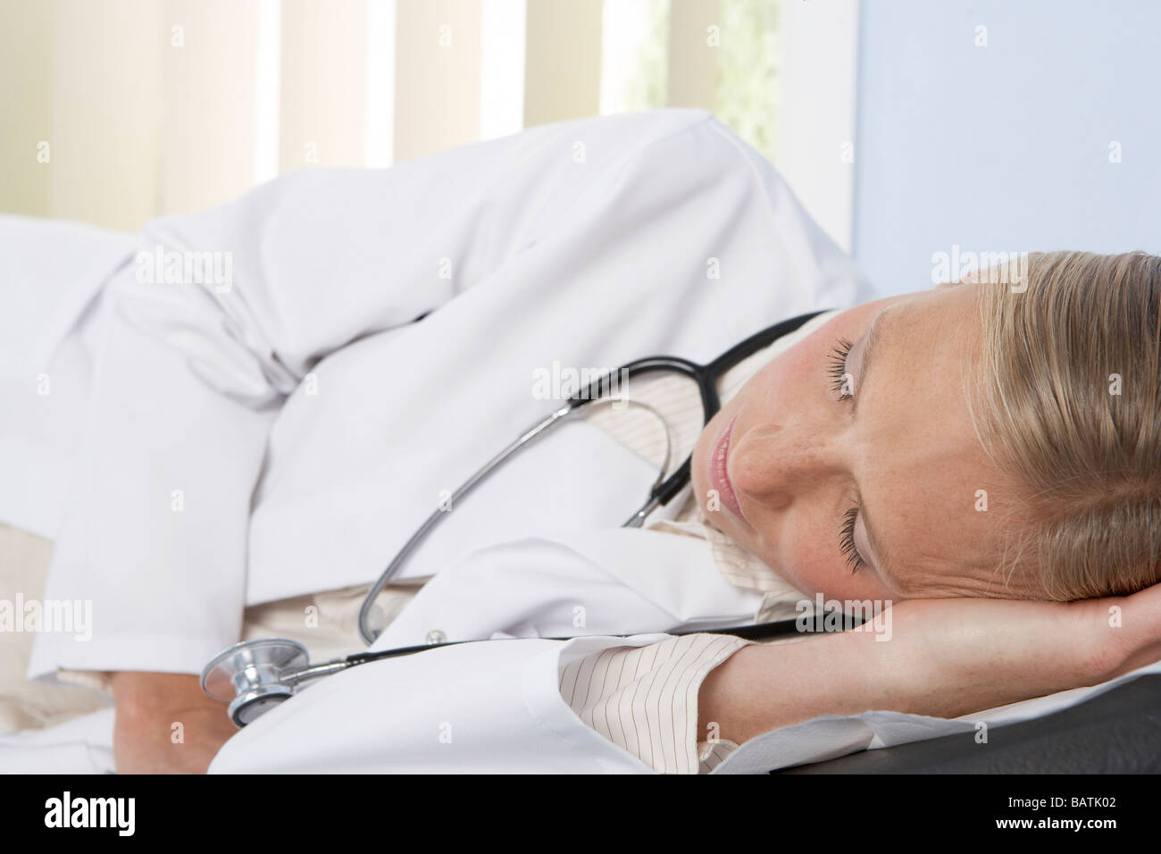 Sleeping doctor. Female doctor sleeping in a hospital rest room Stock